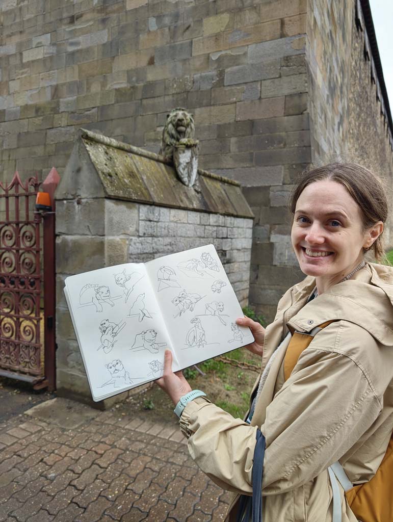 A woman smiling holding a sketchbook