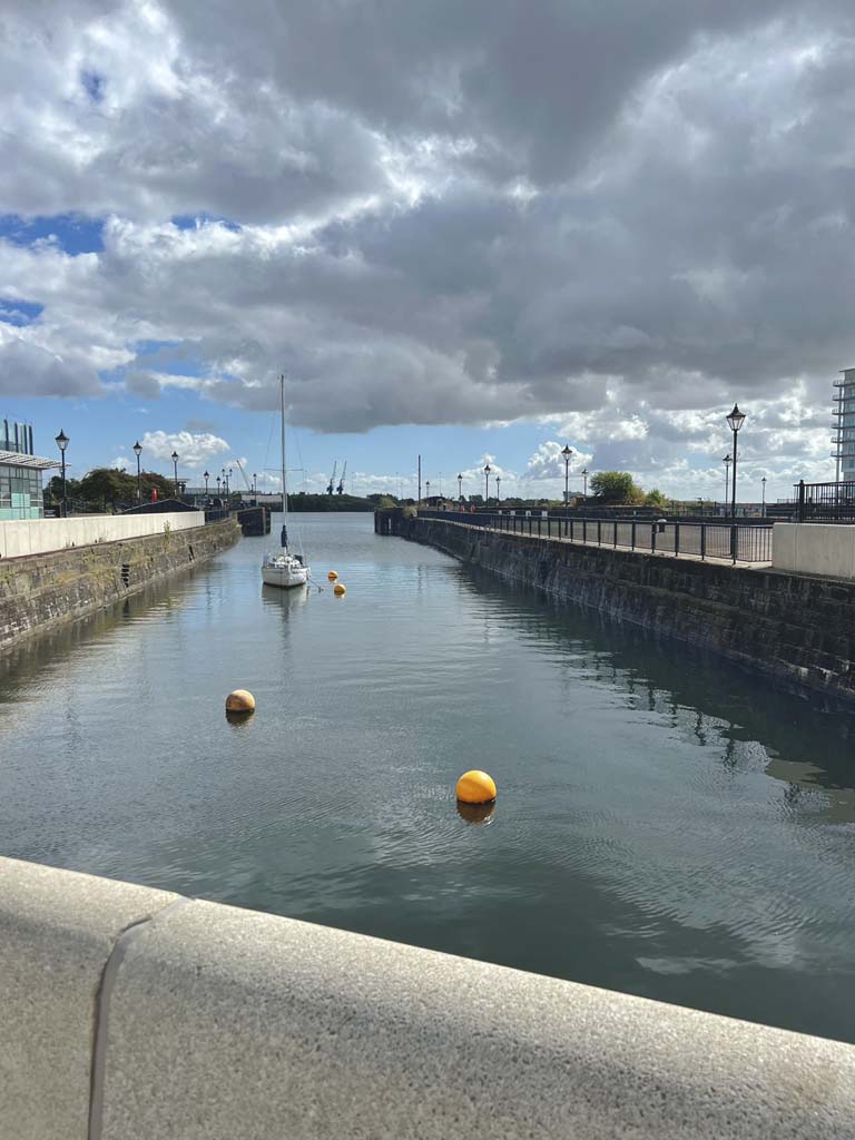 A harbour with a boat and a buoy with blue skies and clouds
