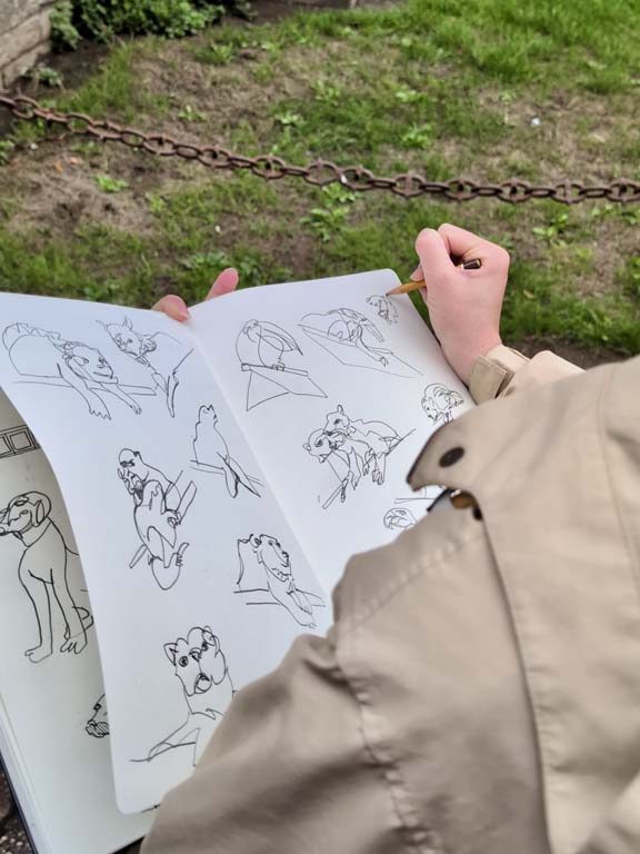 A sketchbook with a woman's hand drawing
